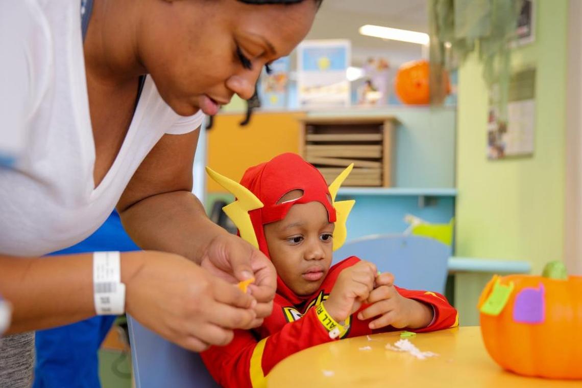 Brittany Fluellen, Jovon’s mother, helps him paint and decorate a foam pumpkin at Alex’s Place inside the Sylvester Comprehensive Cancer Center at the University of Miami on Oct. 24, 2017. Jovan, diagnosed with a rare form of stage 2 lymphoma, is receiving stell-cell treatments to replenish his supply of T-cells, which help fight infection.