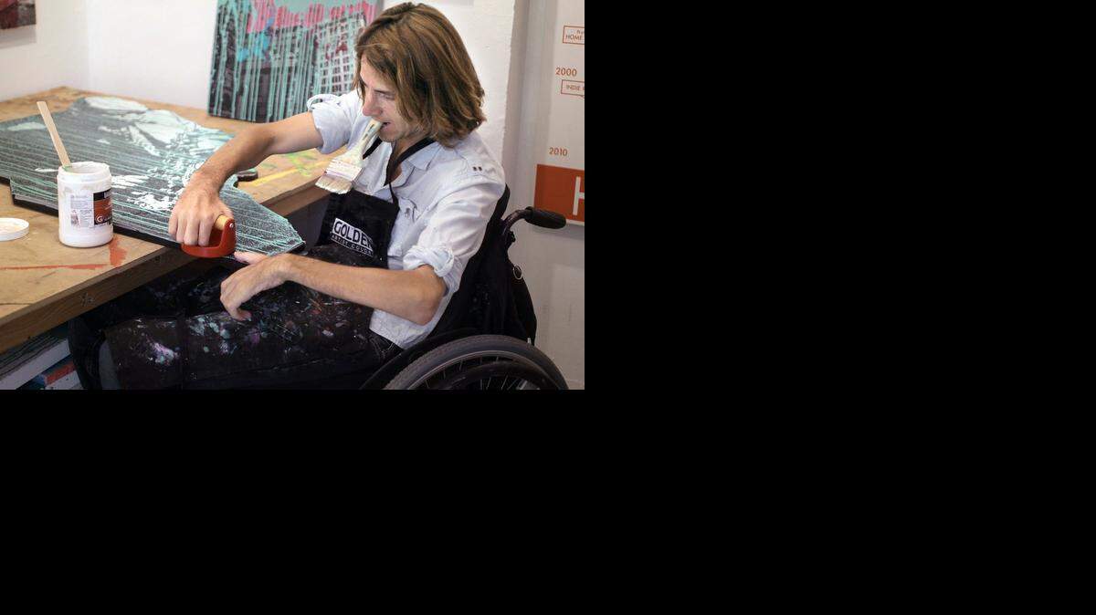 
David McCauley, a mixed-media artist and the founder of Rise Up Gallery, smooths the edge of one of his new artworks at ArtCenter / South Florida in Miami Beach.  Rise Up Gallery is a nonprofit organization that provides free art therapy workshops to the community and a venue in which emerging artists can exhibit their work. McCauley sustained a spinal cord injury in 2008 while diving; he is among nearly 35 resident artists at ArtCenter in South Beach. He also partners with Jackson Rehabilitation Hospital to provide free art therapy workshops to inpatients and outpatients who have spinal cord injuries.
