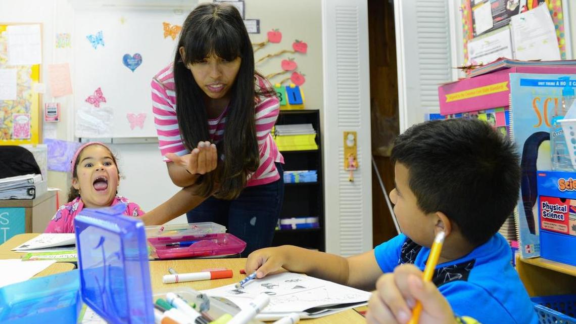 Faith Fellowship School teacher’s assistant Lauren Gonzalez, 20, helps first graders Jenesis Martinez, (left) and Yosbel Marichal (right).