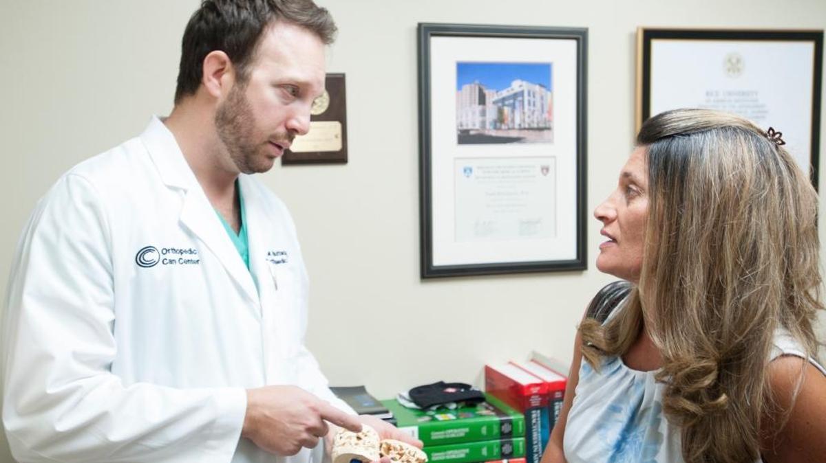 Dr. Frank Buttacavoli, an orthopedic surgeon, discusses osteoporosis with his patient, Sara Bahar, in his office at Orthopedic Care Center in Aventura.