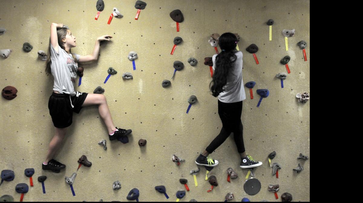 
Liana Martinez, left, and Suraia Akhter, both 11 and in 6th grade, climb the rock wall in the fitness center at Nautilus Middle School, 4301 North Michigan Av., on Miami Beach, Wednesday, November 23, 2011. Jayne Greenberg runs Miami-Dade County Public Schools' P.E. program on a shoestring, and is responsible for helping to get fitness centers, like this one, into Miami-Dade County Public Schools. 
