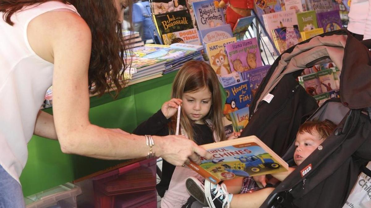 In 2015: Christine Stuyck of Miami, left, reads a book to her children, Pia, 4, and Rafa, 1, in the Usborne Books exhibit at the 32nd Miami Book Fair at Miami Dade College Wolfson Campus in downtown Miami.