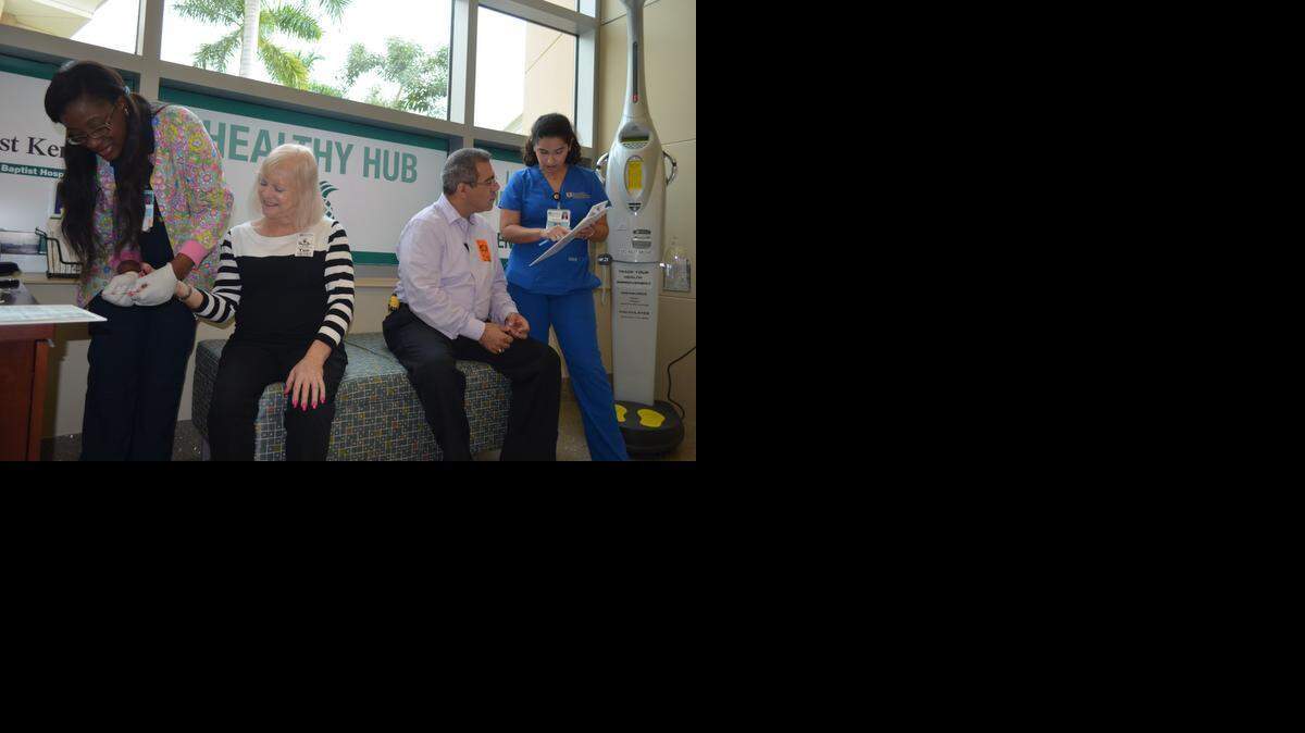 
CHECKING MARKERS: Julie Fanfan, R.N., left, assists Helene Frankel while José Martinez receives information from Naya Alfonso, R.N., at the Healthy Hub in West Kendall Baptist Hospital.
