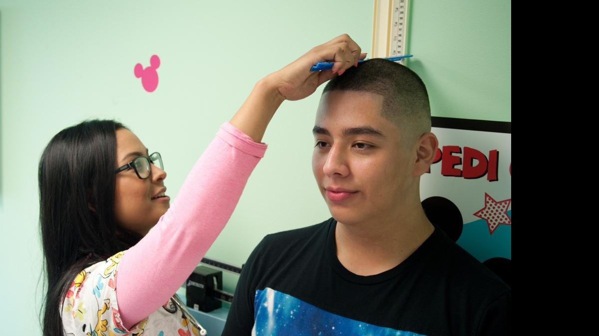 
On the right track: Gisselle Nogueira, a medical assistant at Nicklaus Children's Hospital, measures Jose Amaya, 14. Jose takes part in a weight-management program at the hospital.
