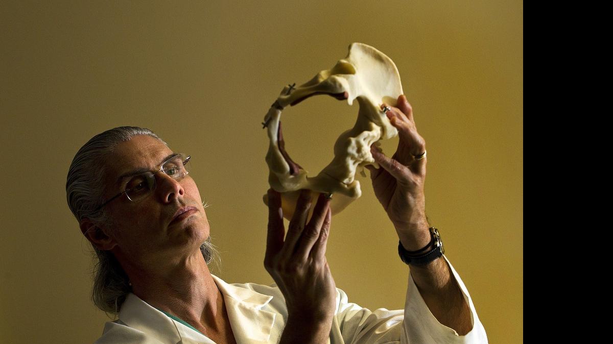 
STRENGTH EXERCISES: Dr. Rafael Perez of South Miami Hospital looks at a model of a pelvis. Therapy to help strengthen the pelvic floor is the first line of defense for stress incontinence, Perez says. 
