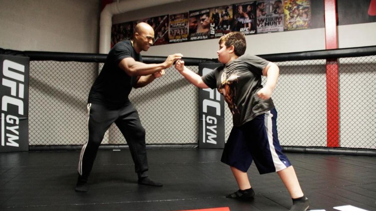 UFC GYM coach Yannick Hunt teaches striking technique to 8-year-old Jayden Albanes. UFC GYM Kendall, open 24 hours, seven days a week, offers martial arts classes and fitness equipment.