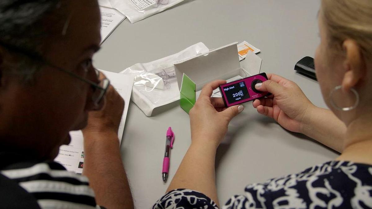 Igor and Olga Quintero program the monitoring system for their daughter Ivanna Quintero, 11, who has diabetes.