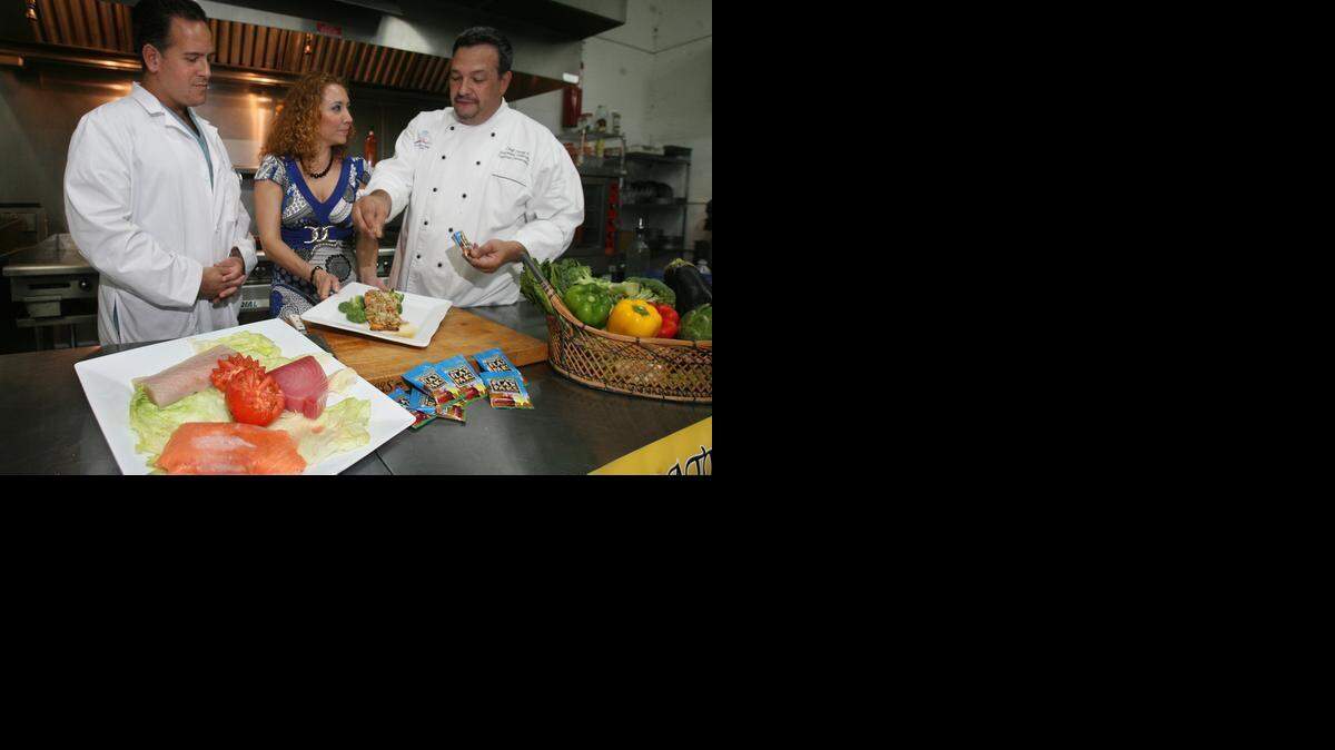 
FLAX SEEDS: Chef Petey Jimenez (right) sprinkles some of flax seeds on a salmon dish that he prepared while dietician Ximena Jimenez and Dr. Dean Heller observe in a 2008 photo. The chef is combining two heart healthy foods. Ground flax seeds are a plant-based source of Omega-3 fatty acids, rich in fiber. Helps reduce blood cholesterol. They reveal most of their healthful benefits when ground, however.
