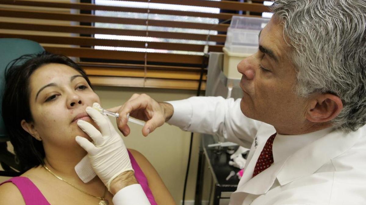 Dr. Carlos Wolf injects a patient with a facial filler called Restylane. Non-surgical treatments can boost your skin as you age.