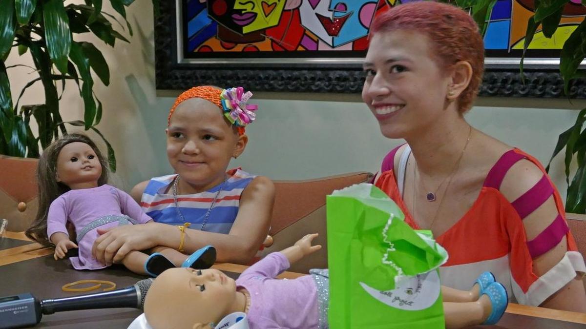 Georgina, a little girl with cancer, and Raquel Coronell, 17, who also has cancer, with bald American Girl dolls at Nicklaus Children’s Hospital on March 11, 2016.