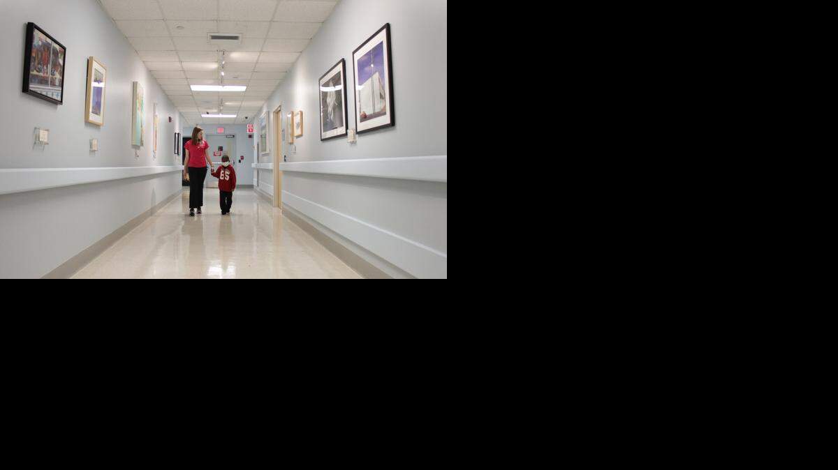 
HALLS OF HAPPINESS: Kaiden Balfour, 6, walks through the Holtz Children’s Hospital’s seventh floor hall with Elizabeth Carrol, 24, a child life specialist, while looking at recently hung artwork. Kaiden was diagnosed with leukemia and has recently undergone a bone marrow transplant.
