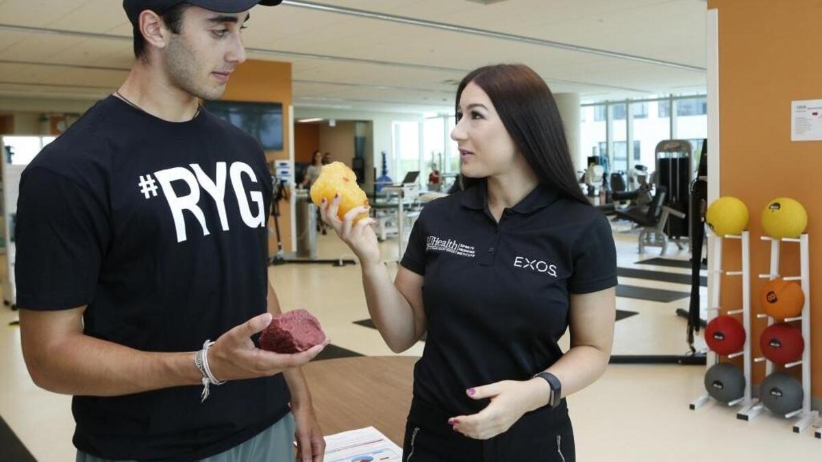 Cara Axelrod, a registered dietitian with EXOS, a sports performance program that's part of UHealth Sports Medicine, meets with high school students, including David Hazday, to coach them about proper nutrition while they train. Here, Axelrod compares a pound of lean tissue to a pound of fat.