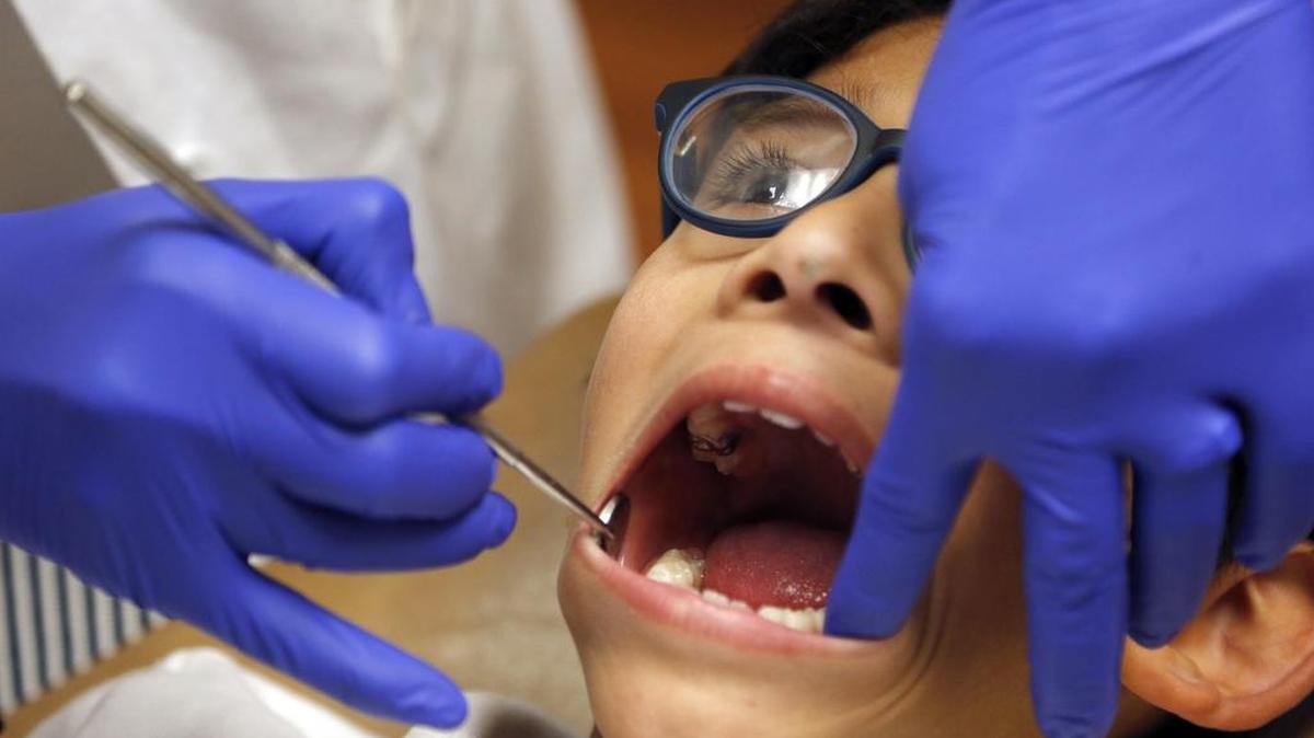 Dr. Rosie Roldan, director of the pediatric dental center at Nicklaus Children's Hospital, left, examines the teeth of Mateo Villalobos, 7.