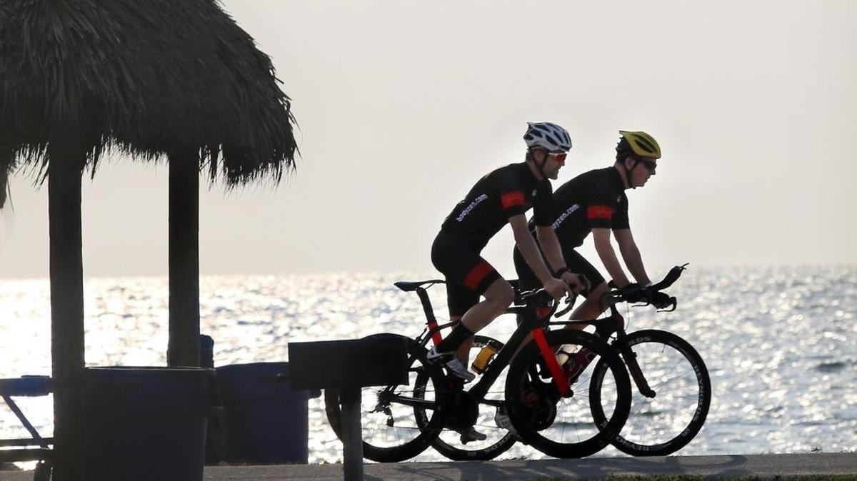 Endurance sports coach Lee Zohlman of Coconut Grove, left, and Joe Flynn of Fort Lauderdale pass a chickee hut during warm-up bicycling runs on Virginia Key. Flynn will compete in the South Beach Triathlon on April 3. Part of his training regimen includes eating correct carbs.