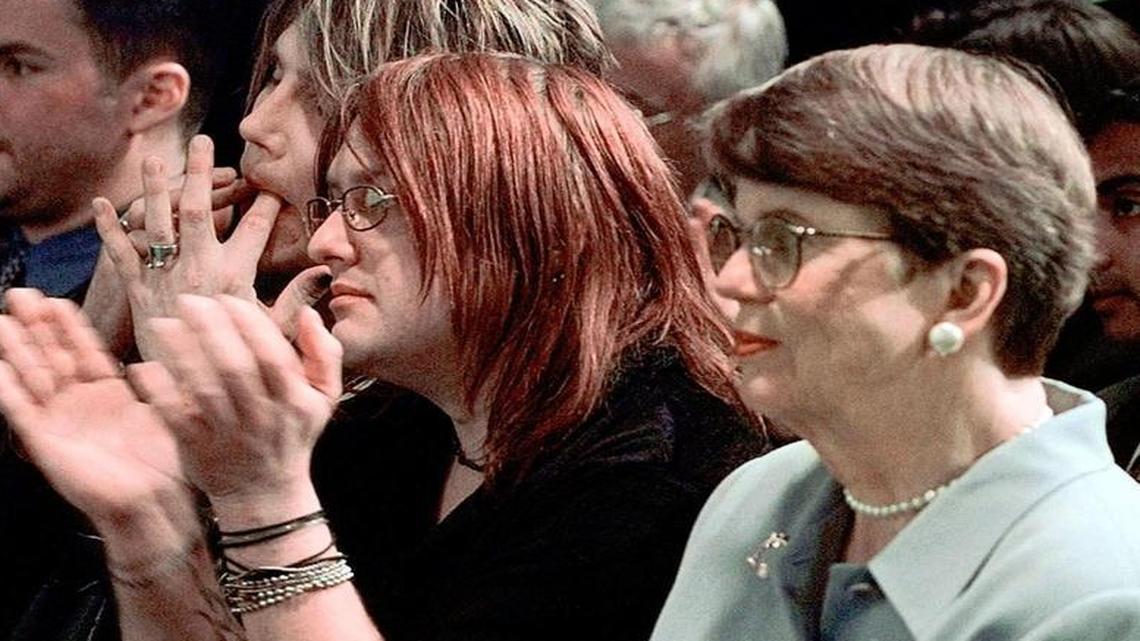 Attorney General Janet Reno sits with musicians John Rzeznik, left, and Robby Takac, center, members of The Goo Goo Dolls rock group, at a news conference announcing the "Fight for Your Rights: Take a Stand Against Violence" campaign, at New York's MTV Studios, Friday, May 7, 1999. MTV along with the U.S. Dept. of Justice and U.S. Dept. of Education introduced an anti-violence youth action guide and compact disc to be distributed to more than one million young people across the country.