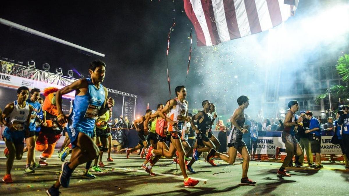 Elite athletes begin at the starting line of last year’s Miami Marathon and Half-Marathon in front of the AmericanAirlines Arena in downtown Miami.