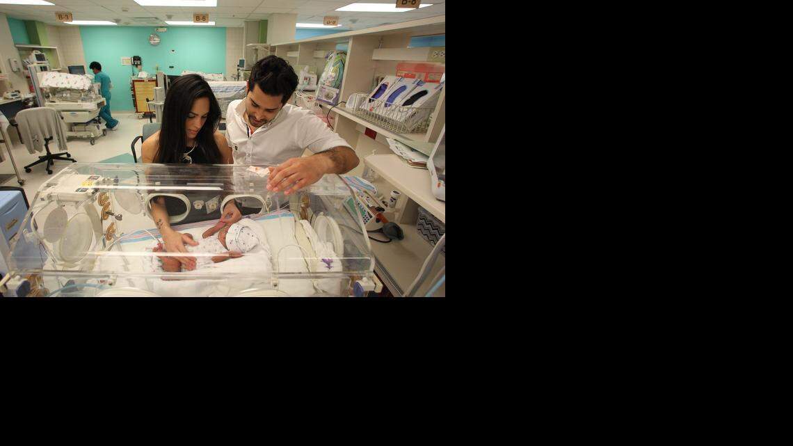
HEALING TOUCH: Ivanna Cardenas and David Gutierrez, the parents of quadruplets born prematurely, perform massages to stimulate growth. They have learned how to do this from Tiffany Field, the University of Miami researcher who pioneered massaging to stimulate growth for preemies.
