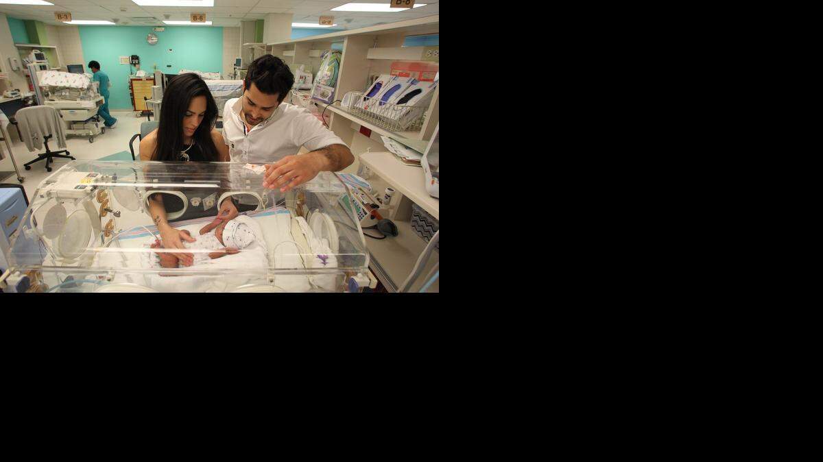 
HEALING TOUCH: Ivanna Cardenas and David Gutierrez, the parents of quadruplets born prematurely, perform massages to stimulate growth. They have learned how to do this from Tiffany Field, the University of Miami researcher who pioneered massaging to stimulate growth for preemies.
