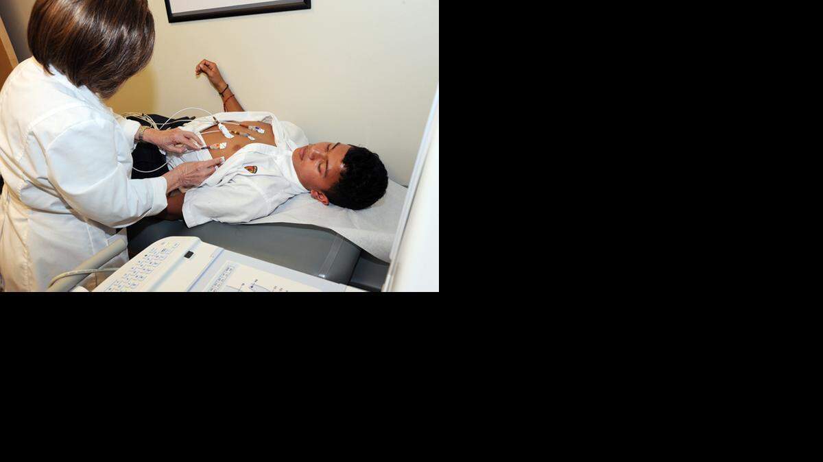 
testing: An EKG technician at Miami Children’s Hospital performs a screening on Belen student Israel Lopez Murillo.
