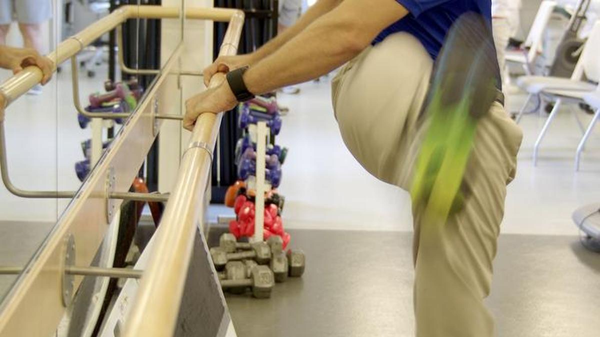 
David Huie, 27, a doctor of physical therapy, demonstrates the dynamic stretch for the back and hips, swinging the leg from left to right in a smooth motion, inside the Krupa Center at Cleveland Clinic Florida in Weston.
