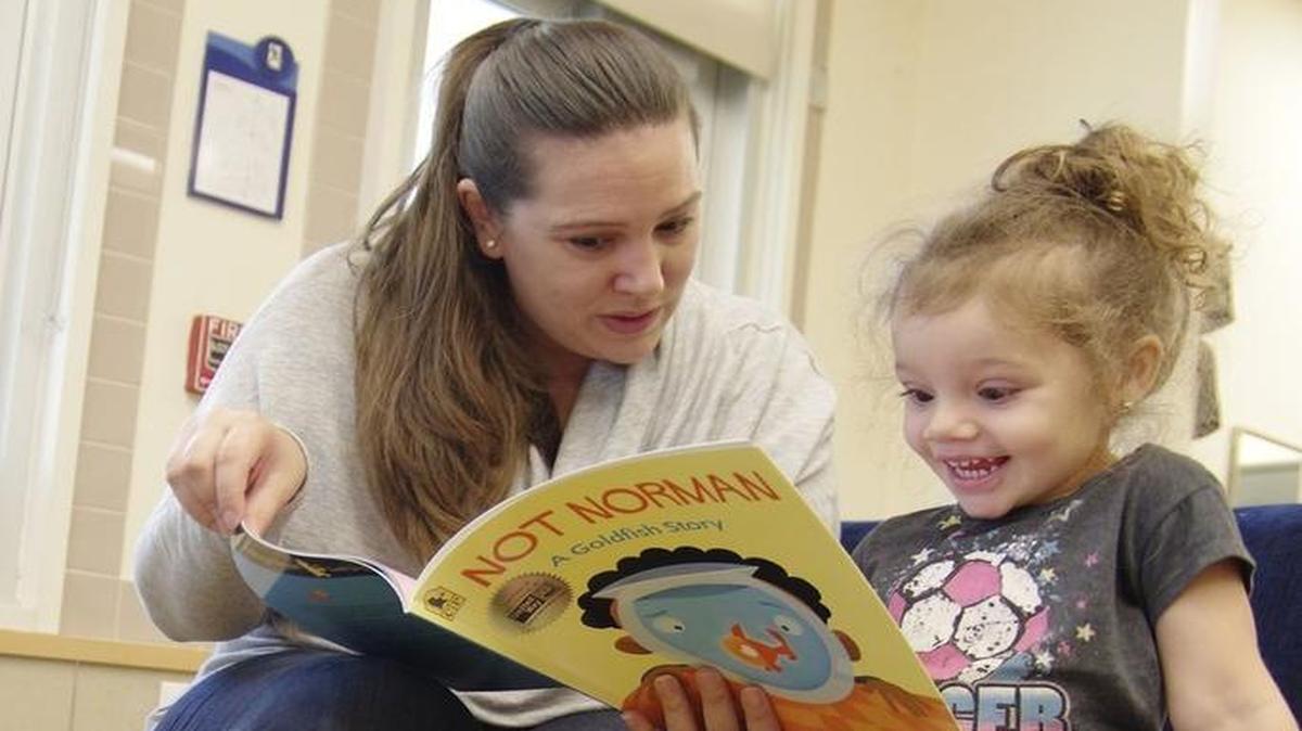An excited Kathleen, 3, listens as young leader Alana Greer, 30, from the Community Justice Project reads “Not Norman: A Goldfish Story” by Kelly Bennett during the United Way of Miami-Dade's Read for the Record a nationwide campaign, where millions of adults read the same book to young children to raise awareness for early childhood literacy at the United Way Center for Excellence in Early Education in Miami.