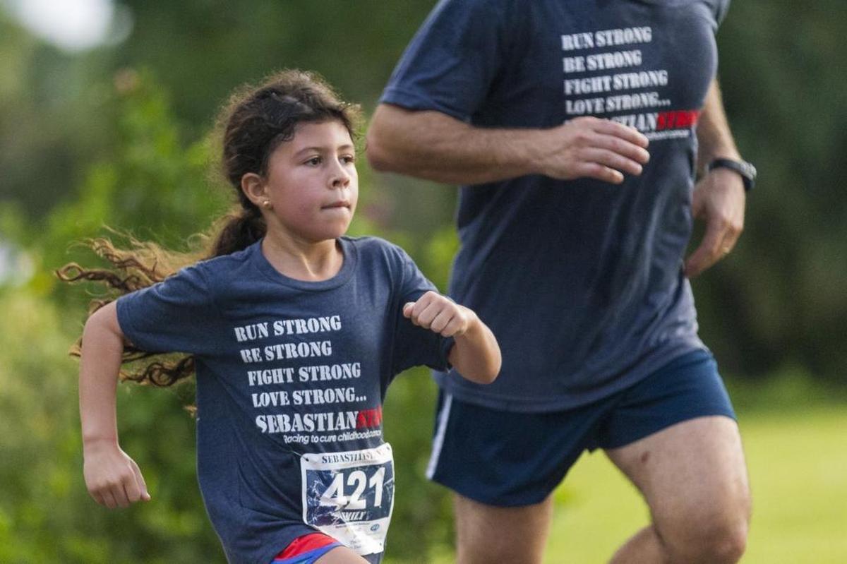 Emily Veiguela, 6, and her uncle, Joel Veiguela, 40, participate in the SebastianStrong 5K in Miami Springs on Saturday, Nov. 4, 2017. The event aims to raise awareness, fund research into curing childhood cancer and honoring Sebastian's life.