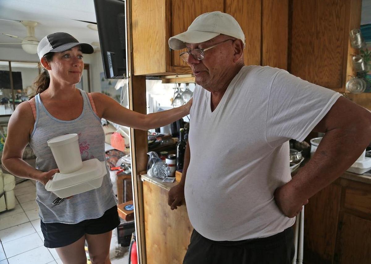 Chef Layla Barr, left, tries to comfort Bill Dicioccio, 75, right, a veteran whose trailer home suffered heavy damage and is facing possible evacuation. Barr is one of the founders of Nourishing the Lower Keys, a group of Key West women making meals to distribute to workers, volunteers and residents rebuilding Big Pine Key.