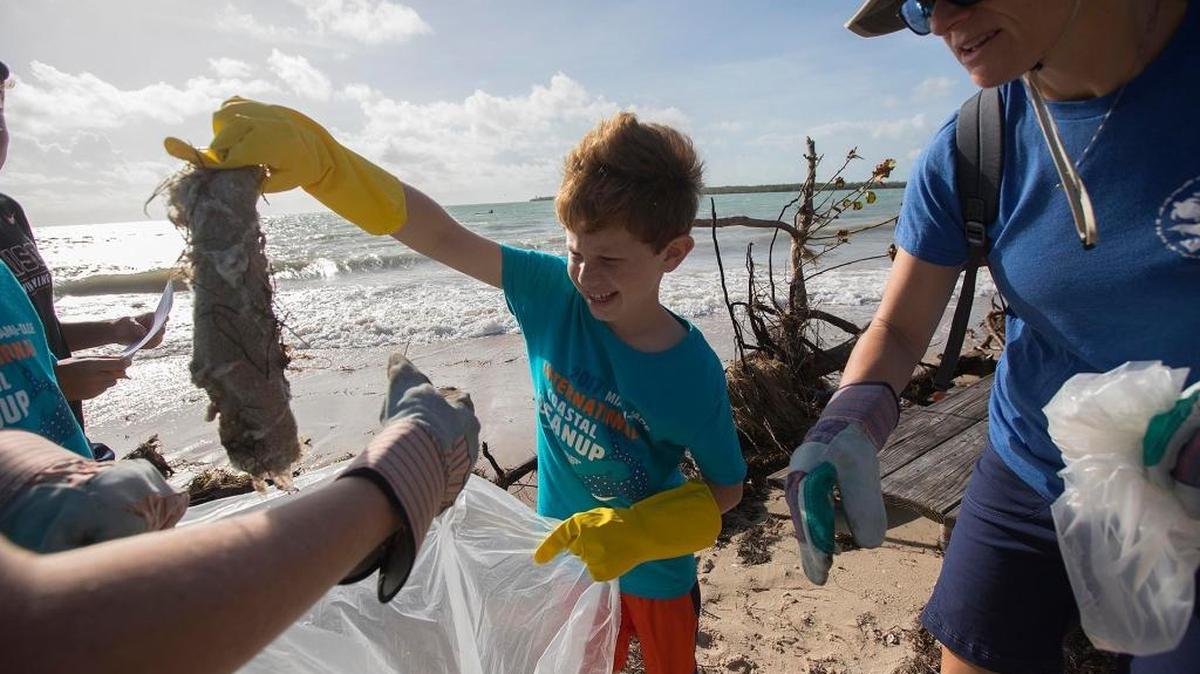 Joseph Reiter, 10, finds garbage by the coast during International Coastal Cleanup day, on Saturday, Oct. 22, 2017. Virginia Key Beach Park. (R) Joseph's mom, Jill Reiter.