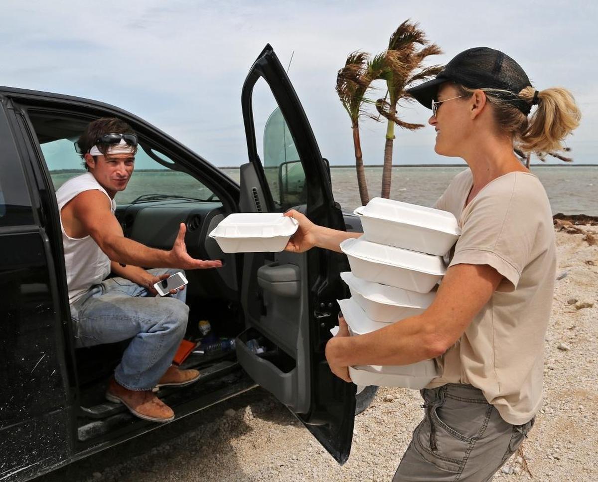 Volunteer Margit Bisztray, right, delivers food to a worker in the heavily storm damaged area of Big Pine Key on Oct. 25, 2017.