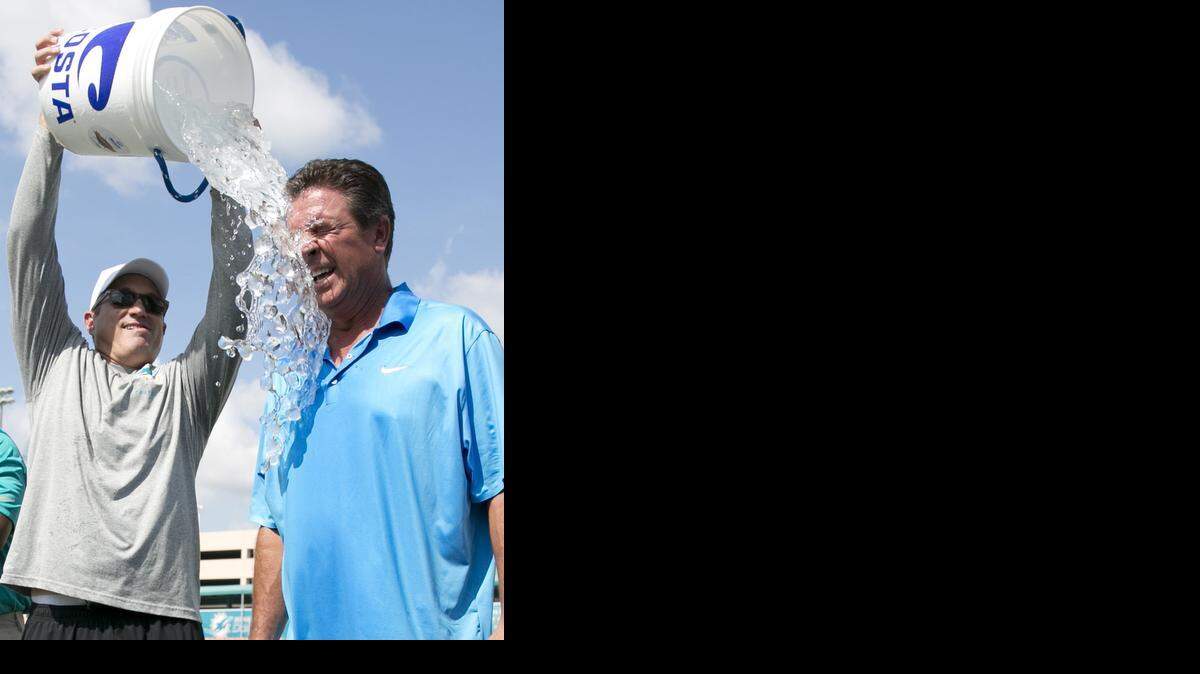 
DOUSED FOR A GOOD CAUSE: Miami Dolphins CEO Tom Garfinkel dumps a bucket of ice water on Dan Marino during the ALS Ice Bucket Challenge at Miami Dolphins training camp. People gave more than $100 million through the Challenge to the ALS Association, a 3,500-percent boost from the same period last year.


