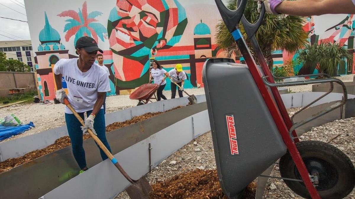 Jasmin Grant, a United Way volunteer, helps plant a vegetable garden at the Opa-locka Community Development Center on Oct. 28.