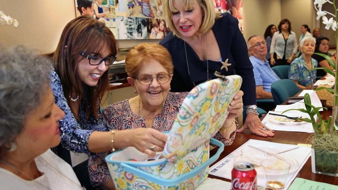 Lupe Bruneman, left, shows Golden Wishes recipient Marta Dupont, middle, accessories for her new sewing machine on Friday, Sept. 30, 2016. United Way of Miami-Dade, working with Dr. Rudy Moise, is helping senior citizens fulfill their bucket list through United Way’s Golden Wishes program. Cherie Weinstein, right, looks on.