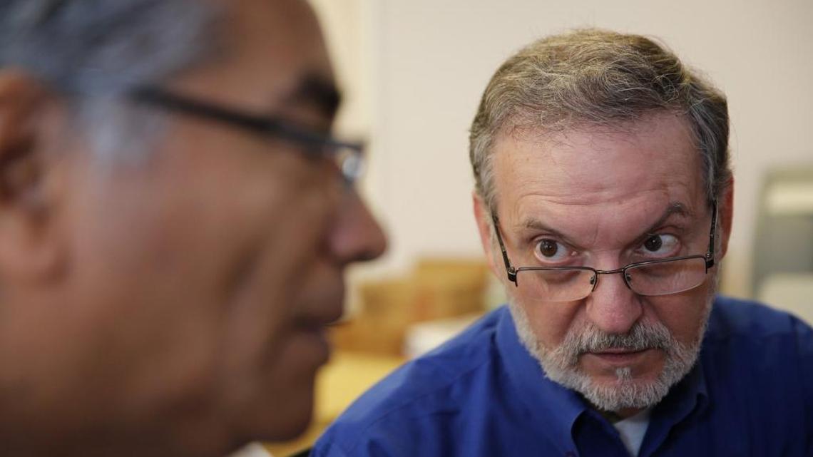 Raúl Hernández of Catholic Legal Services helps Pedro Linares Zelaya fill out a U.S. citizenship application online.