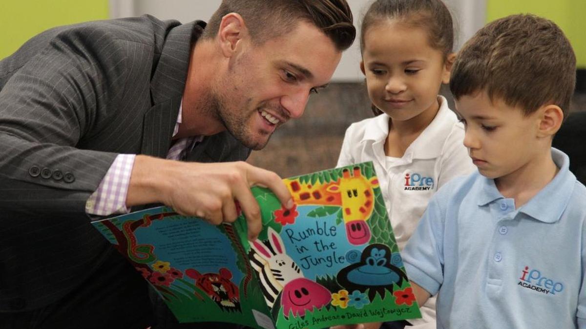 ReadingPals volunteer David Carson, left, reads to preschoolers Sophia Martinez-Henao, 4, and Diego Munoz, 4, right, during their reading session. On Tuesday, October 6, 2015, he read to children at iPrep Academy in downtown Miami as part of the United Way program.