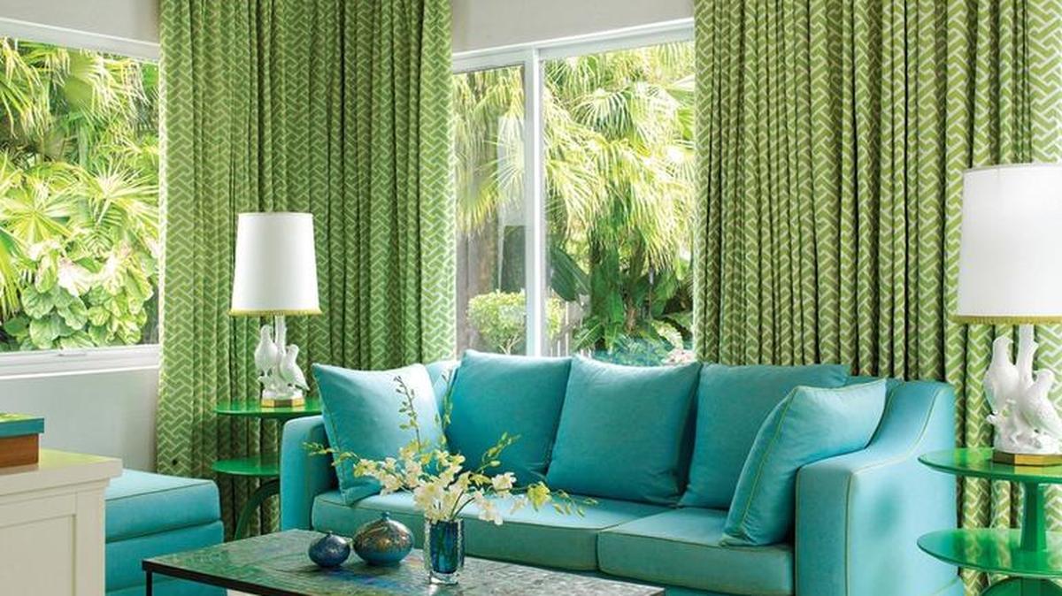 A large-scale organic design of plant fronds called Jasmine in bold colors from NIBA is the grounding element for the decor in this room.