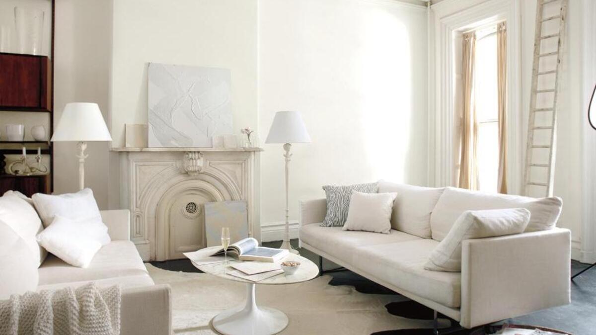 The living room of an abstract artist's townhome is a dream, with its interplay of lights and whites in nuanced, subtle beauty.