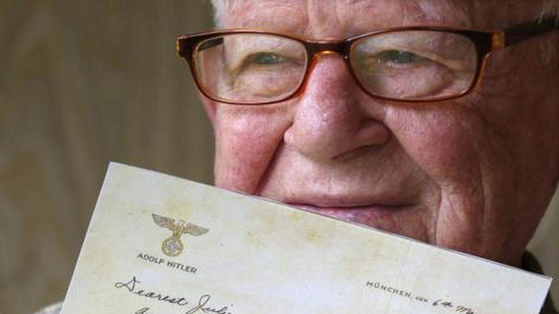 
Danny Jacobson holds a photo copy of a letter written on Adolf Hitler's stationary with a photo of himself as a young soldier in World War II. He found the stationery in an abandoned apartment in Munich.
