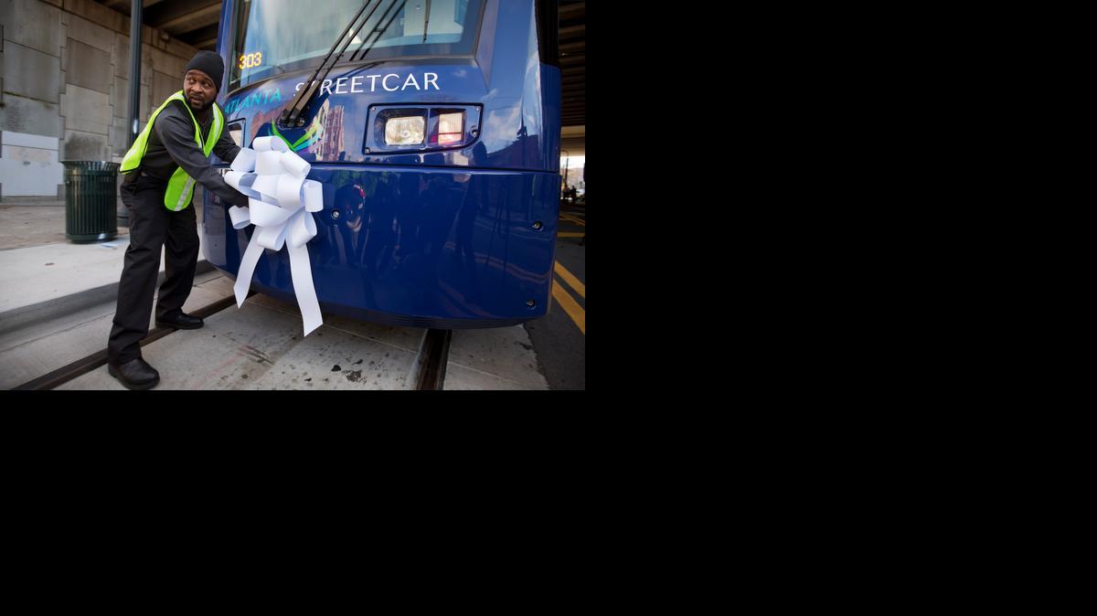 
Operations and Maintenance Supervisor Darius Hall places a ribbon on an Atlanta Streetcar before it makes its inaugural trip through downtown Tuesday.
