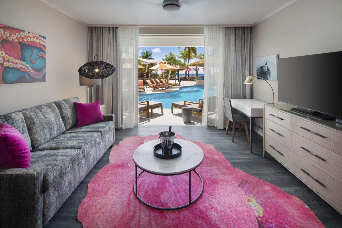 A modern guest room at O2 Beach Club & Spa, designed with clean lines and a coastal color palette inspired by Barbados.