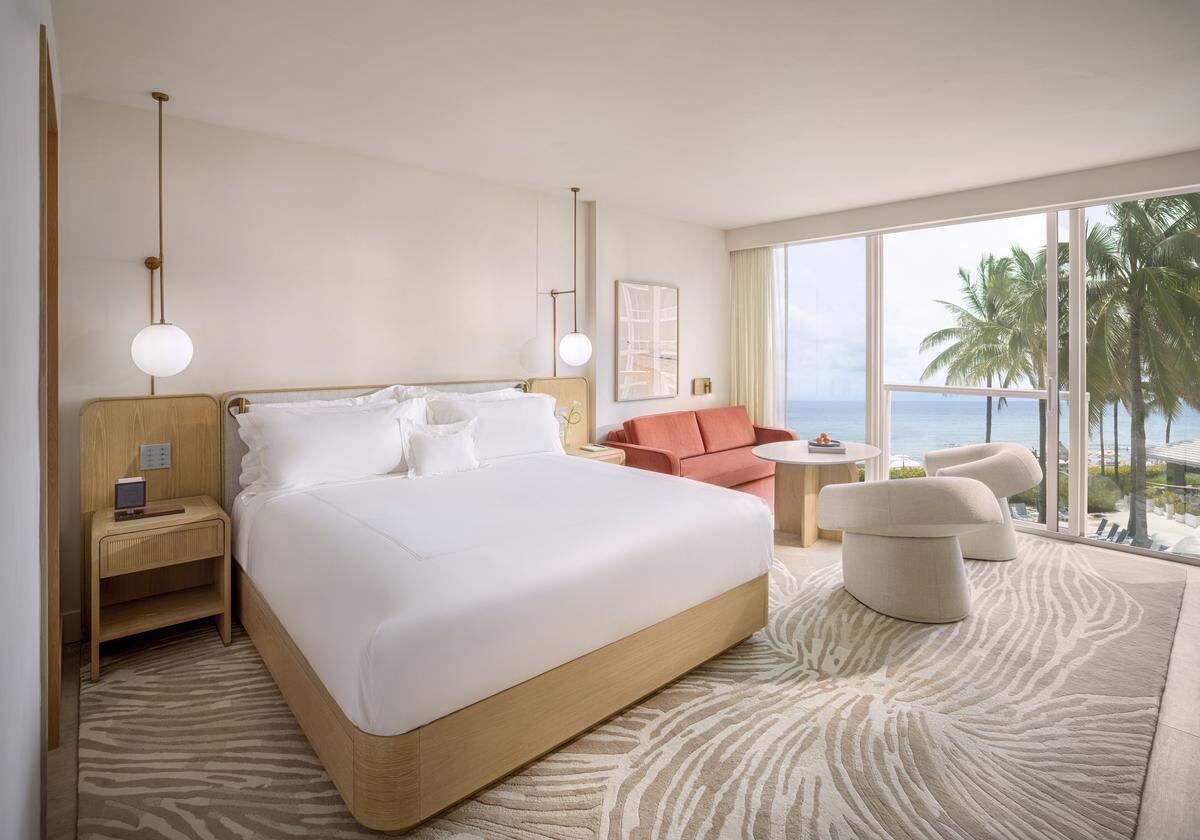 A light-filled king room with ocean views and modern coastal design.