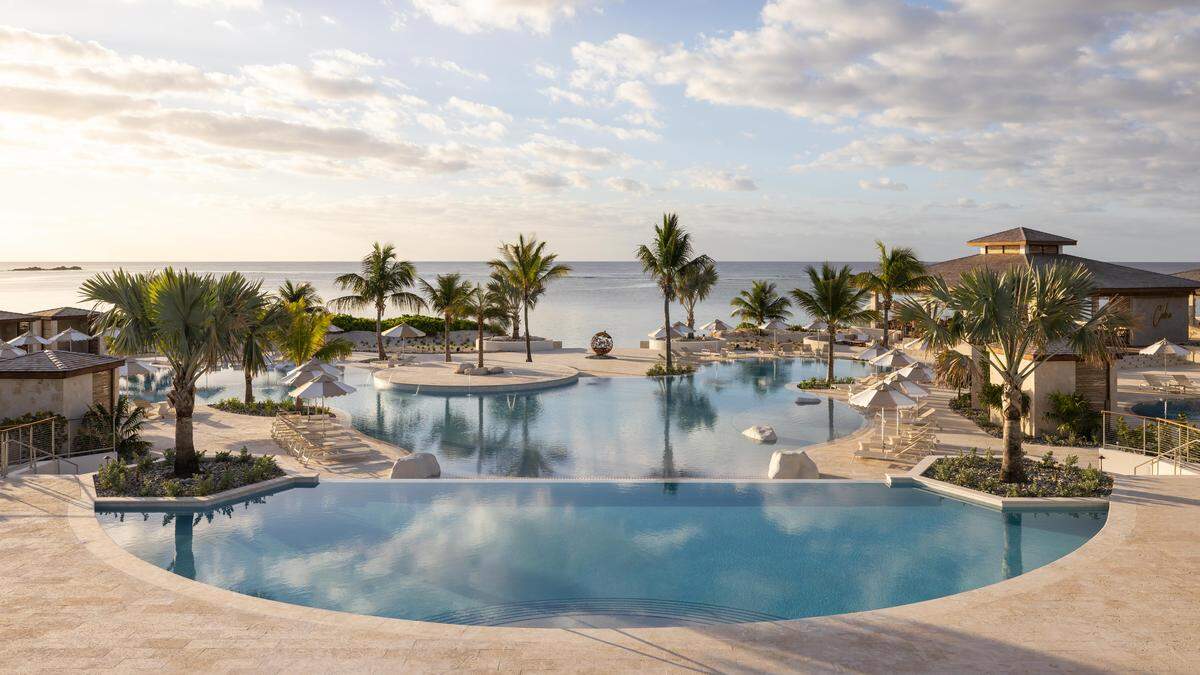 The resort’s sculptural lagoon pool mirrors the horizon, creating a tranquil setting for sunrise swims or sunset cocktails.