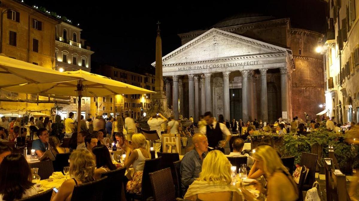 
Ancient monuments, such as the floodlit facade of Pantheon, become part of the social scene in Rome at night. 
