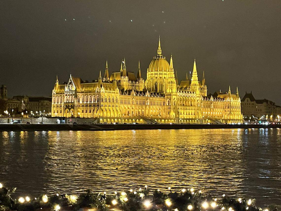The Hungarian Parliament shines over the Danube during the holiday season.