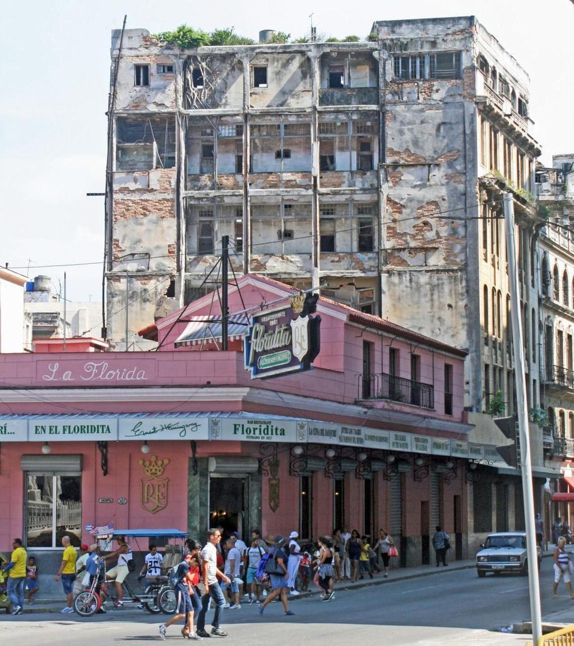 Behind the Floridita, the bar where the daiquiri was invented more than a century ago, a deteriorating building with the roots of rooftop plants growing down through its walls.