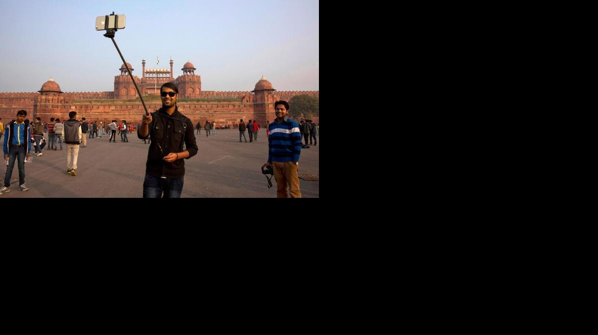 
An Indian tourist uses a selfie stick to take a photograph in front of the historical Red Fort monument in New Delhi, India.
