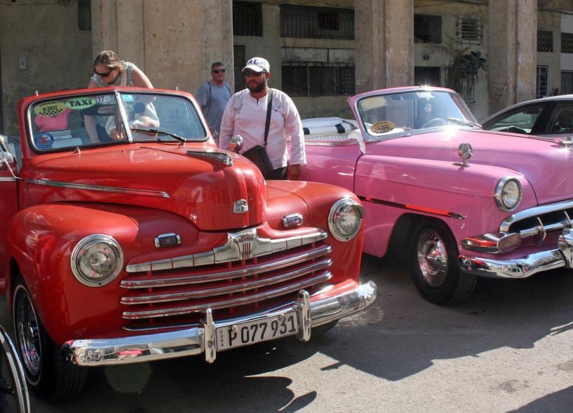 Classic American cars ready to take tourists for a ride along the Malecon.