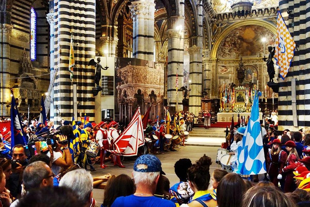 Representatives of Siena’s neighborhoods, each with its own colorful costumes and banners, gather at the cathedral.
