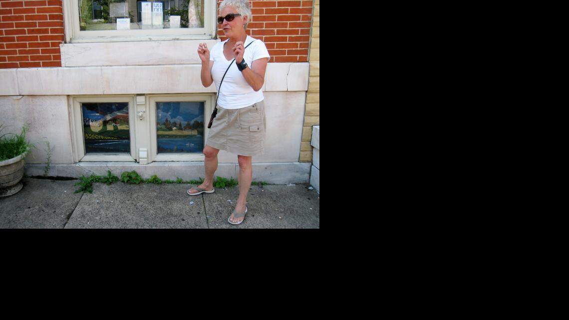 
Artist Monica Broere talks next to painted window screens in the Highlandtown neighborhood of Baltimore. 
