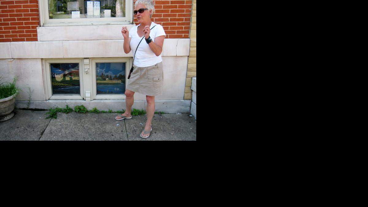 
Artist Monica Broere talks next to painted window screens in the Highlandtown neighborhood of Baltimore. 
