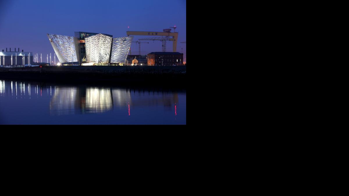 
The Titanic House Visitor Centre is reflected on Belfast Lough, Northern Ireland. The area surrounding the defunct shipyard where the doomed Titanic cruise ship was built is now called Titanic Quarter and features various Titanic-themed attractions.
